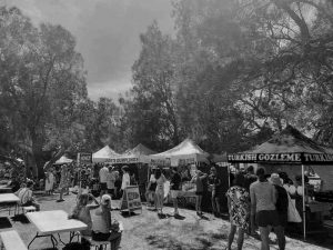 Market Stall Insurance Background Image showing customers purchasing goods from stalls and relaxing