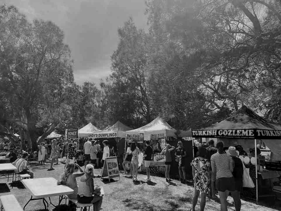 Market Stall Insurance Background Image showing customers purchasing goods from stalls and relaxing